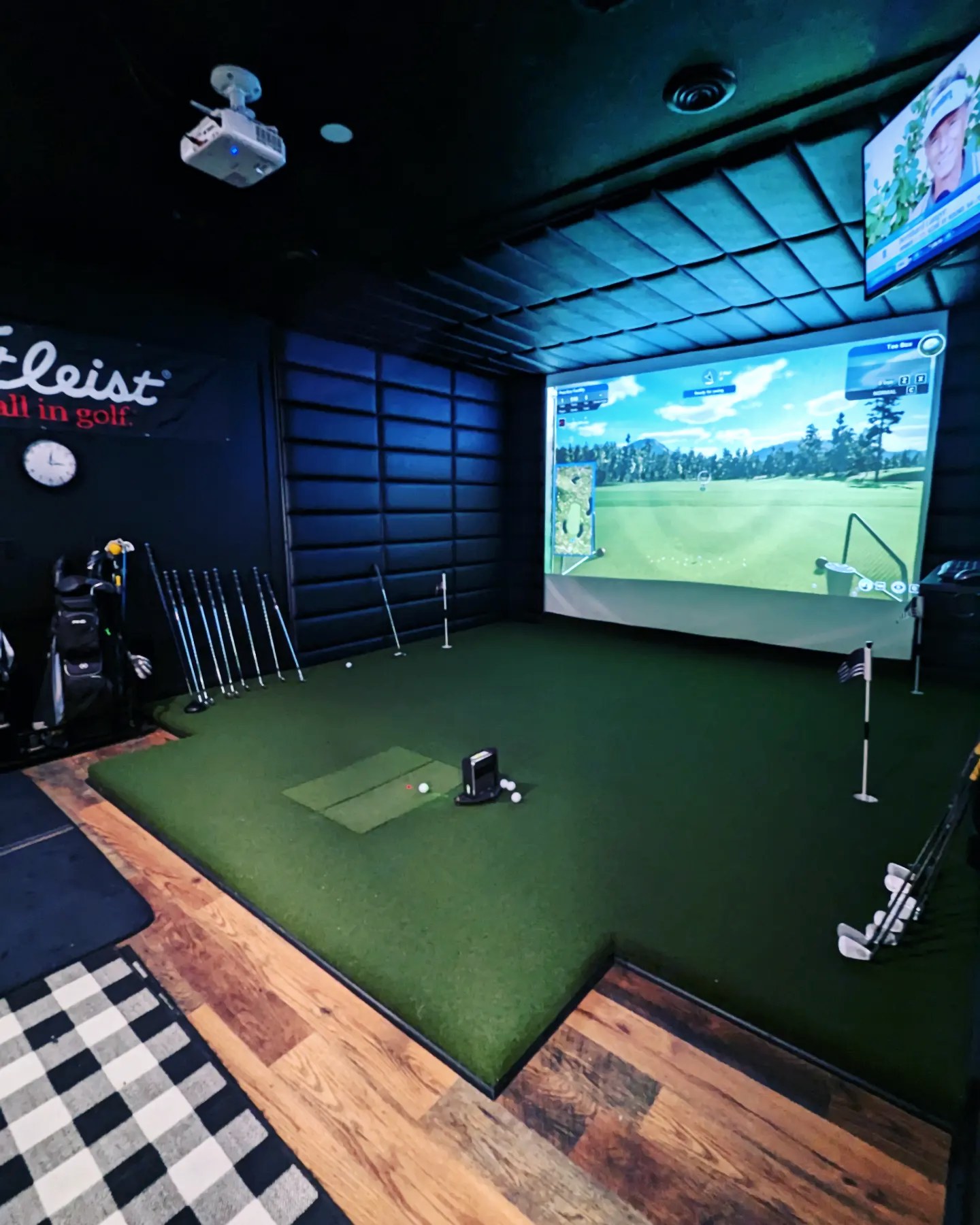 Premium golf simulator room with screen, padded bay, clubs, and hitting area