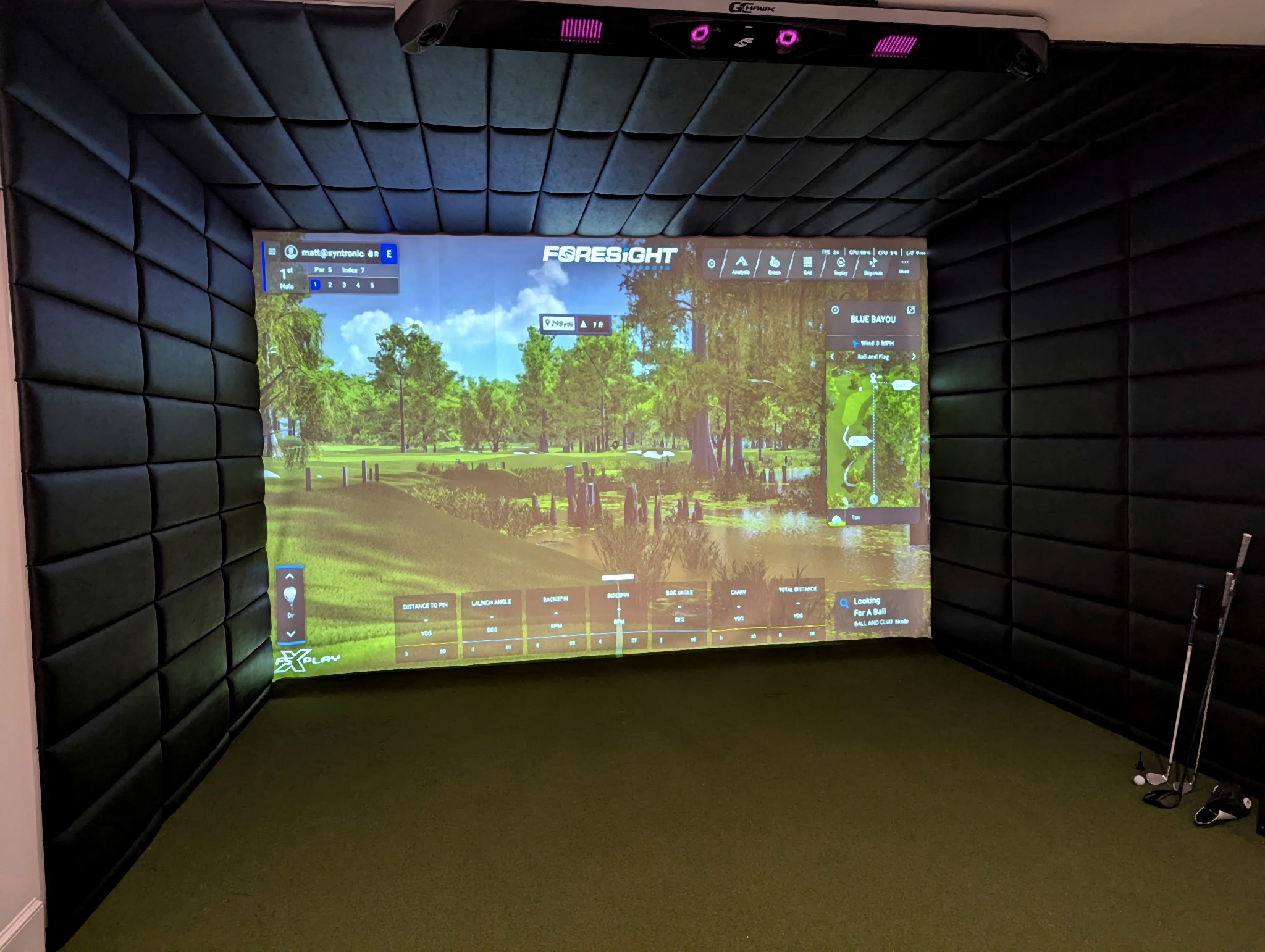 Front view of an installed golf simulator and hitting screen