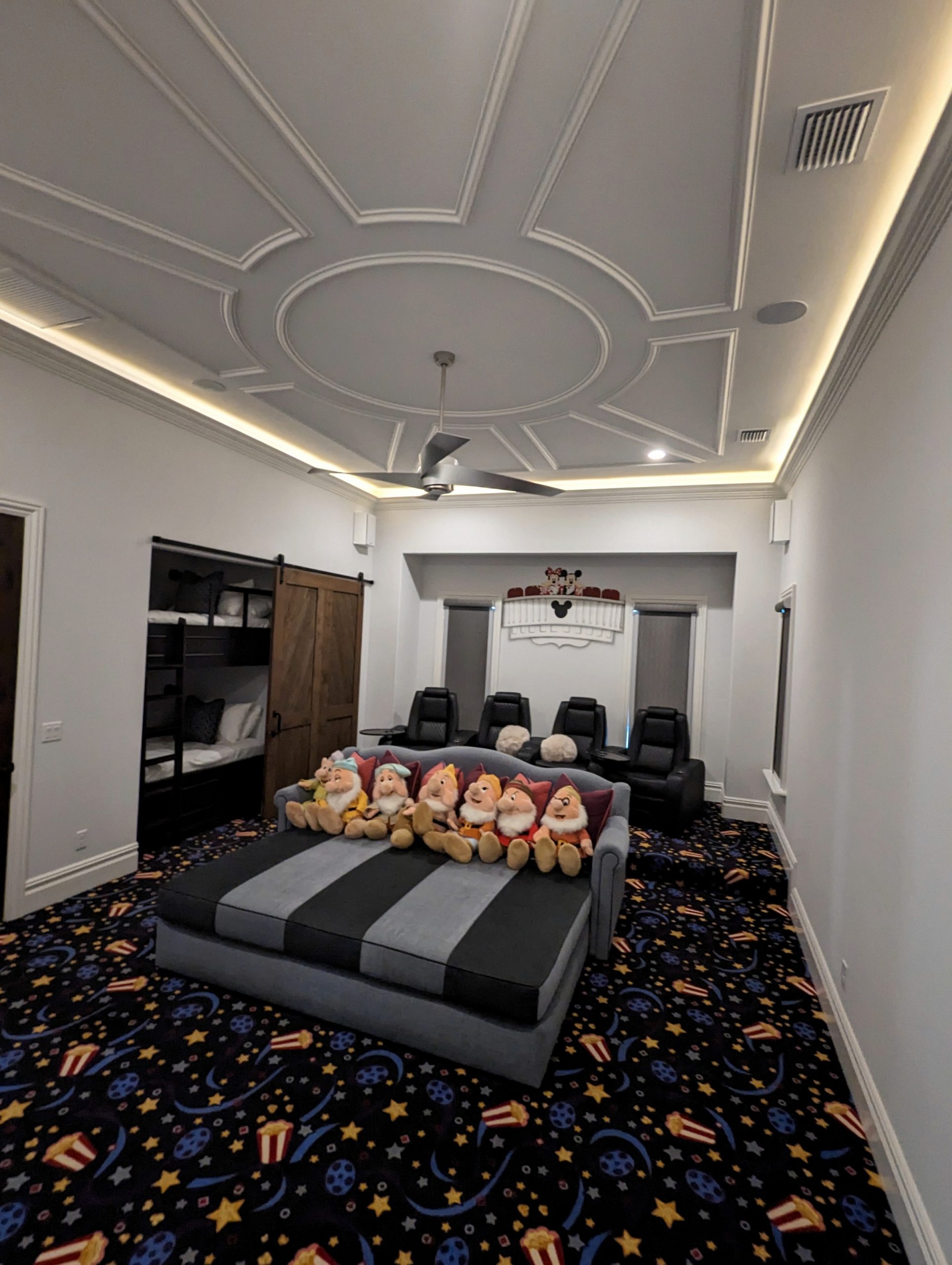 Home theater seating beneath a detailed ceiling treatment